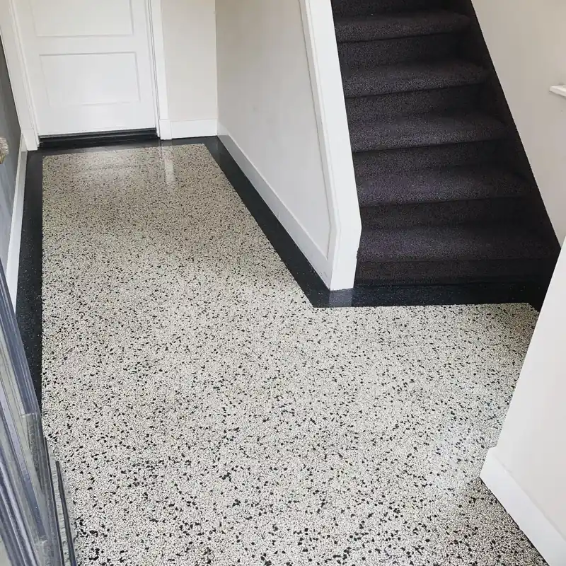 Entryway stairs with black and white epoxy floor flakes